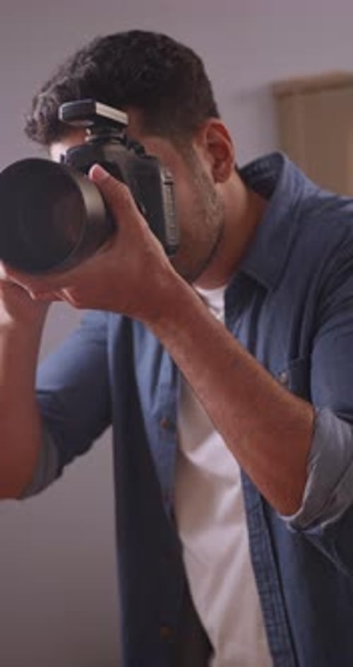 Vertical clip. Professional male photographer working in studio.