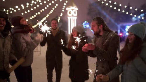 Friends Have Fun Partying with Sparklers and Explode Confetti Cannon at Christmas Market Cheerful