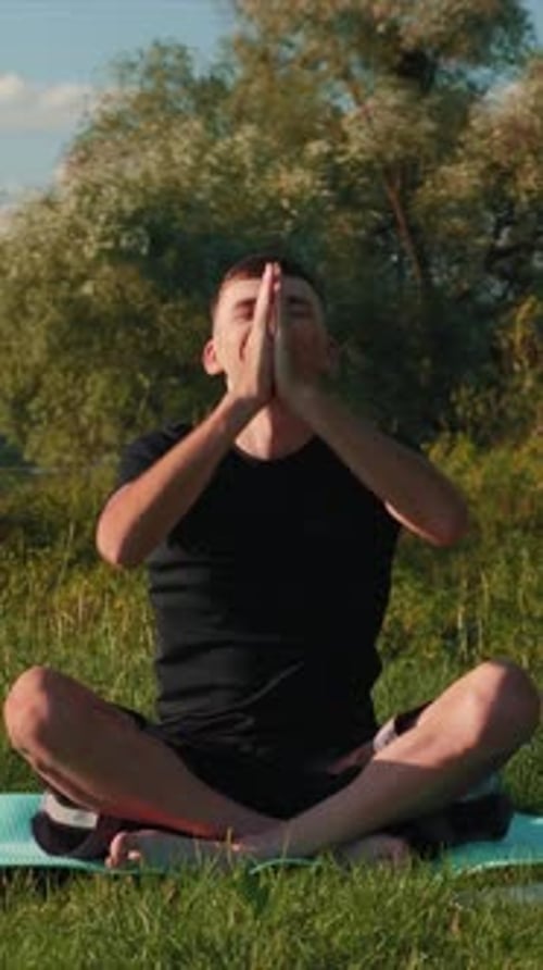 Man Practicing Yoga Outdoors on Green Grass