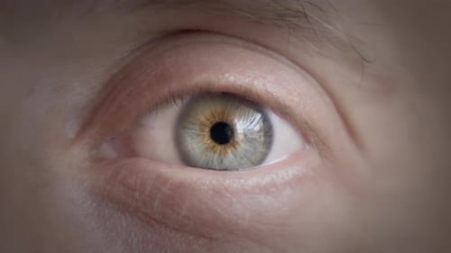 A man's eye slowly opening