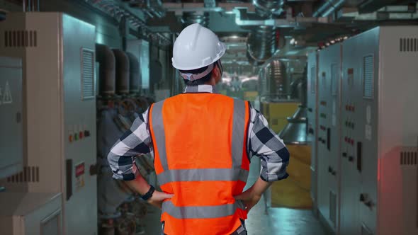 Back View Of A Male Engineer Looking Around With Arms Akimbo In Engine ...