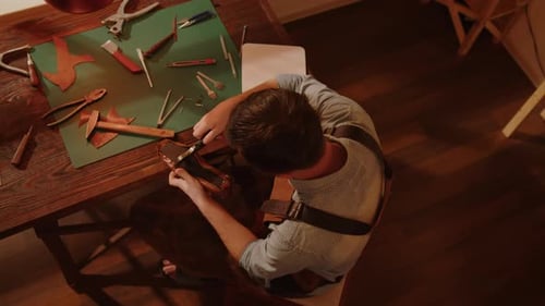 Shoemaker in workshop making handmade shoes top view.