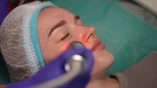 Closeup of Facial LED Therapy with Red Light on Young Woman in Beauty Clinic