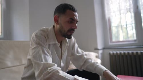 Man Typing on Laptop Computer Indoors While Seated