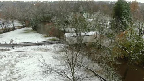 American countryside after first snow in season, covered bridge hidden behind trees, Lancaster Count
