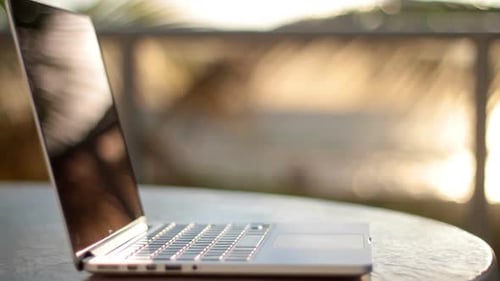 Laptop moderno na praia sob a bela luz do sol, pouca profundidade de campo