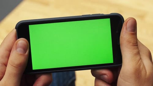 Man Using Horizontal Smartphone with Green Screen Closeup Shot of Man's Hands with Mobile Phone