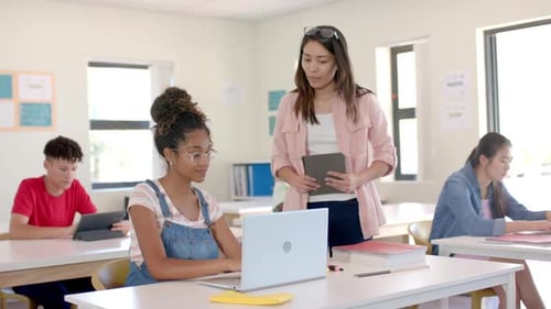 Young biracial woman teaches in a classroom at high school