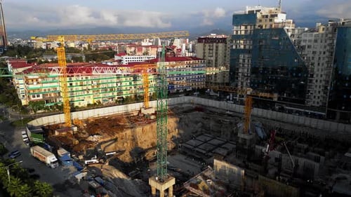 Vista aérea de un enorme pozo en la ciudad con grúas en funcionamiento
