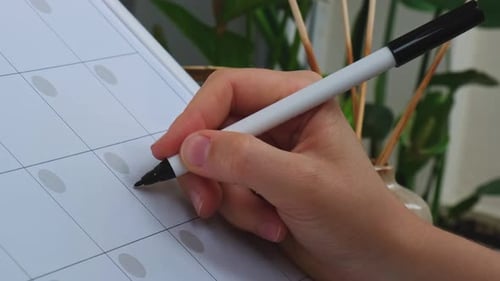 Weibliche Handschrift, Wort zum Jäten, mit Marker auf dem Monatsplaner