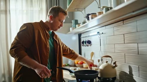 Man Cooking Meat in a Pan at Home