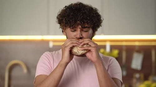 Young Adult Man Eating Burger and French Fry
