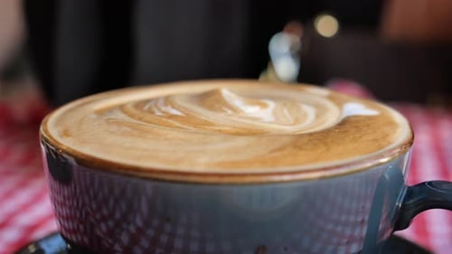 Close Up of Latte Stirred with a Spoon