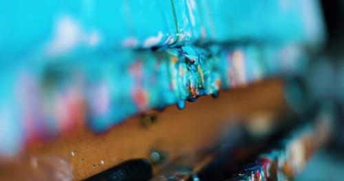 Wet paint dripping from the table of the artist painter. Slow-motion