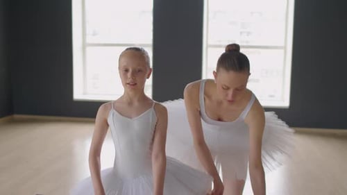 Girl Putting Her Legs on Barre to Stretch It during Ballet Class