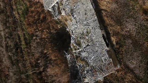 Vertical aerial shot of the destroyed building farm barrack with explosion crater