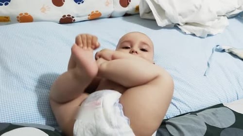 Cute Baby Plays With Feet on Blue Blanket