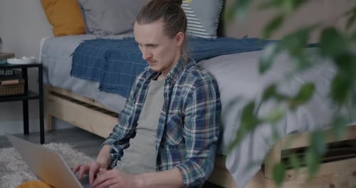 Young Adult Working on Laptop Sitting on Floor