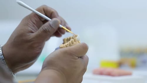Dental Technician Carefully Working on Implant Model