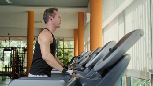 Athletic Man Running on Treadmill at Gym