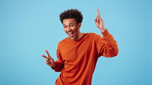 Positive Young Man Winks and Dances Making Funny Movements