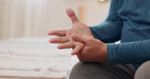 Senior Adult Massaging Hand and Fingers Indoors