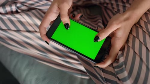 Girl hands using chroma key smartphone on sofa at home