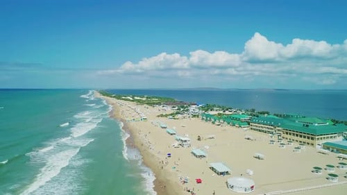 Aerial Over the Long Sandy Spit with a Beach and Azure Water on a Sunny Summer Day Waves Crashing to
