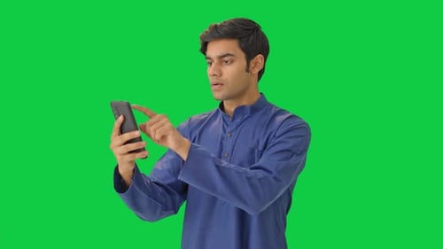 Indian man using mobile phone Green screen