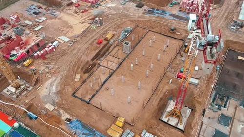 Construction Site with Cranes and Foundations Under Construction Aerial View