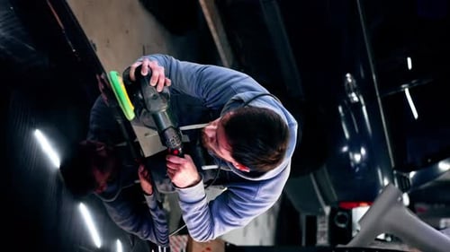 Vertical Video Top Shot the Car Mechanic at a Service Station Doing the Final Polishing to Shine