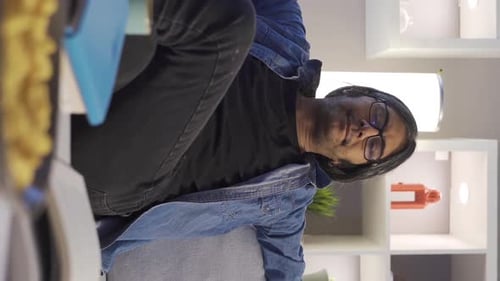 Man Eats Snack and Uses Tablet at Home