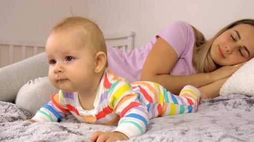 Infant Lying on Bed with Sleeping Parent