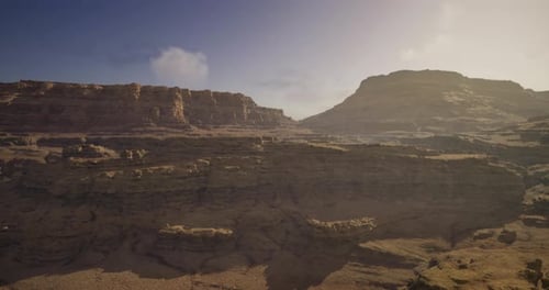 Vast Desert Landscape with Rugged Mountains Under a Bright Sky at Midday