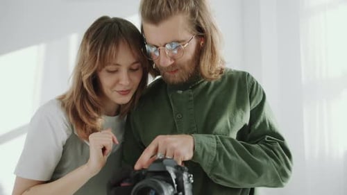 Cheerful Woman and Photographer Checking Photos and Talking in Studio
