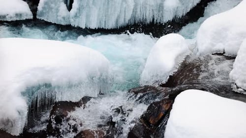 River Stream at Winter Snow Forest in the Mountains