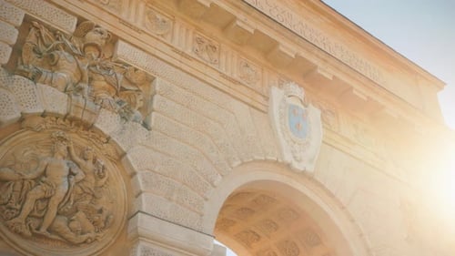 Ornate Stone Archway with Detailed Sculptures and Sunlight
