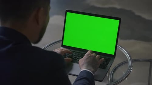 Businessman Typing on Keyboard While Working on Laptop with Green Screen Chroma Key