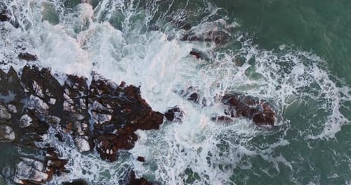 Aerial Top View Of Waves Crashing On Rocks