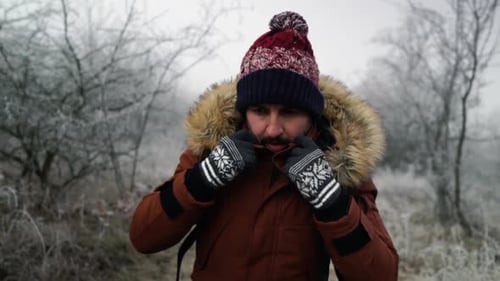 Man Covering Face in Cold, Frosty Landscape