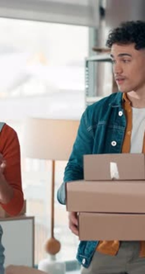 Woman and Man Holding Boxes and Using Tablet