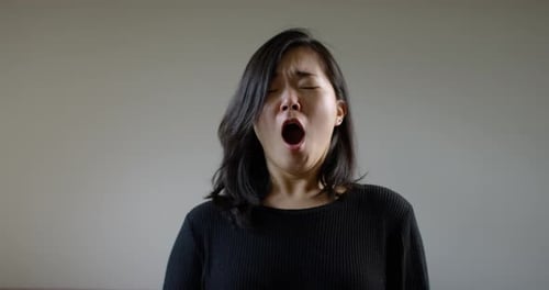 Asiatische Frau niest mit dem Coronavirus