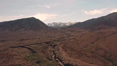 Drone view of a beautiful mountain landscape with crevices and rocks with hills covered with snow