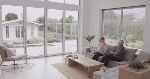 Senior Couple Relaxing and Talking on Living Room Sofa