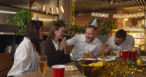 Rapaz loiro feliz com uma barba em uma camisa branca se comunica com seus colegas durante uma festa