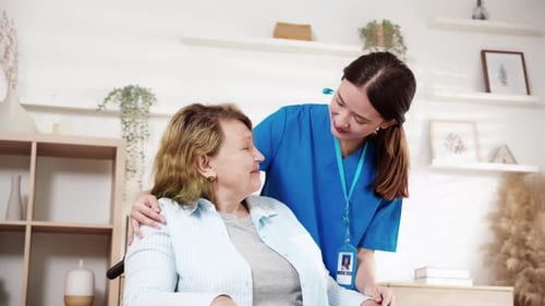 Caregiver Assists Woman in Wheelchair at Home