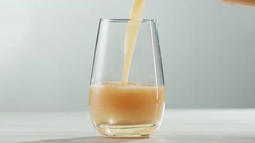 Pouring Peach Colored Liquid into a Glass
