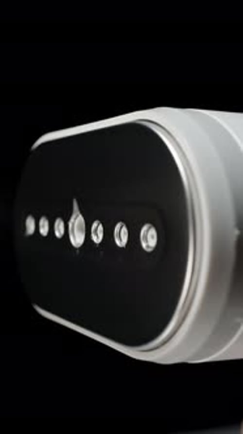 Vertical video. Handheld Garment Steamer Spraying Jet of Steam with Visible Water Droplets in Slow