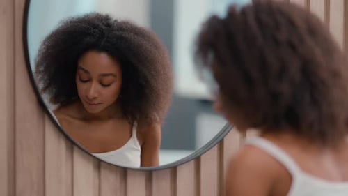 Woman Dries Face in Front of Mirror