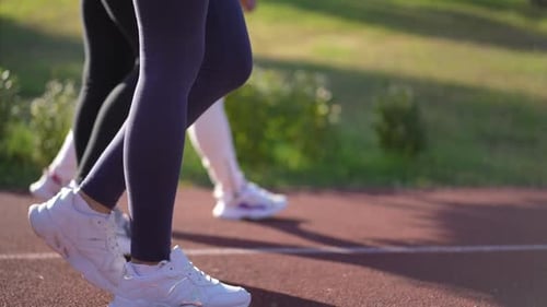 Side View Legs of Sportswomen Walking on Red Sports Track As Live Camera Panning Right to Left